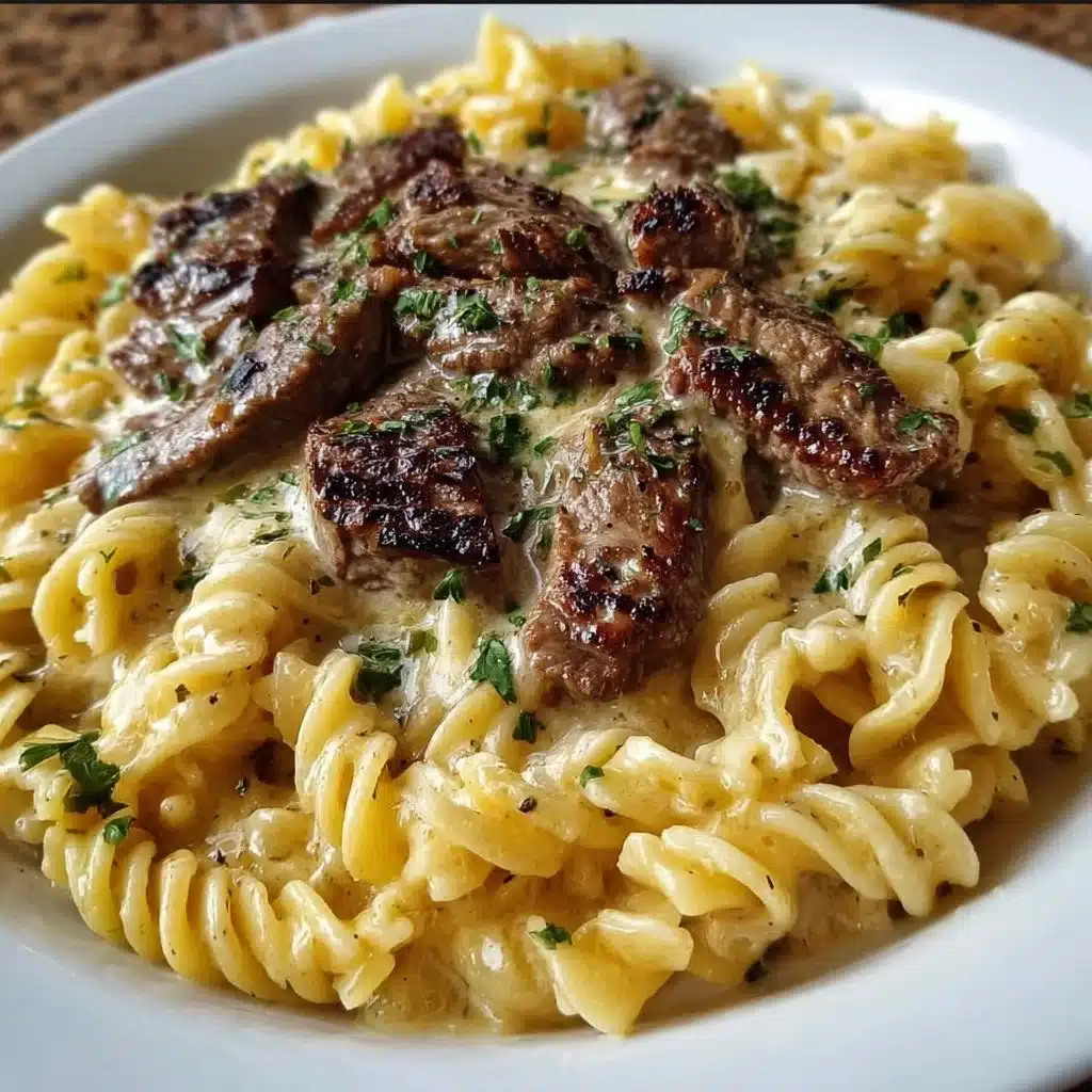 Plate of creamy steak pasta with garlic sauce and herbs